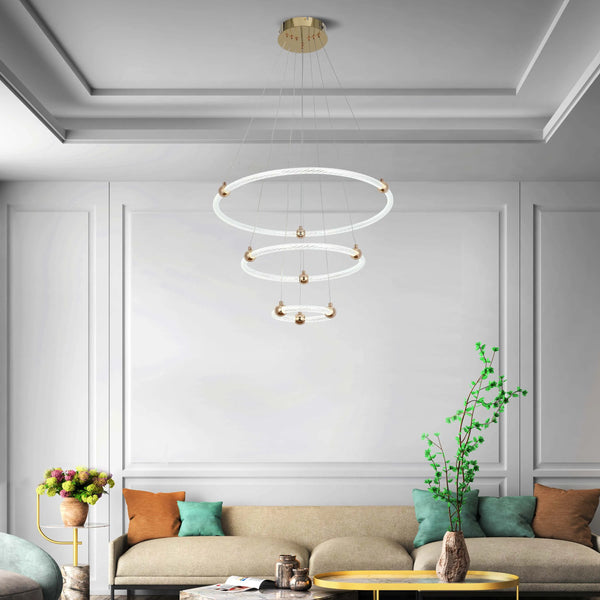 Modern chandelier with three illuminated rings, suspended from a gold ceiling plate. Provides ambient and decorative lighting.