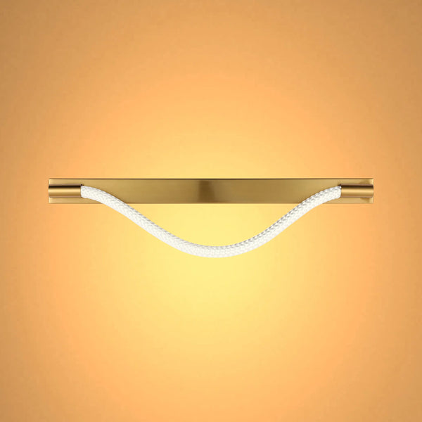 A modern light fitting with a gold fixture and a white rope element, casting a warm and inviting glow.