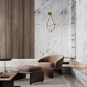 A modern interior showcases a unique wall light with a decorative rope and copper sphere, creating a sophisticated ambience.