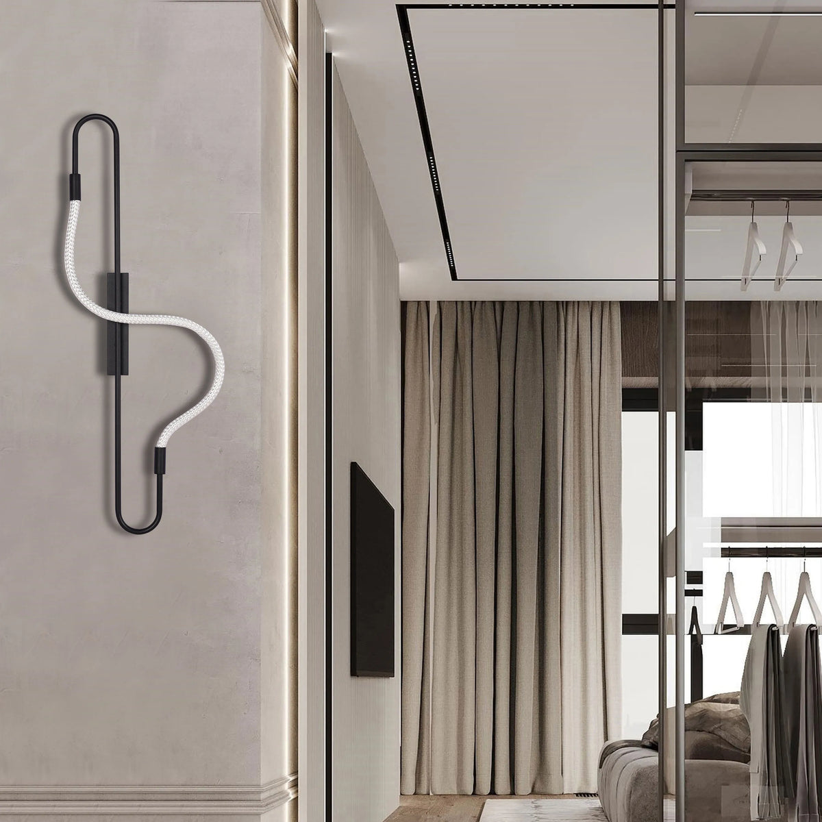 A black modern wall lamp with a twisted white flex wire provides accent lighting in this stylish bedroom.