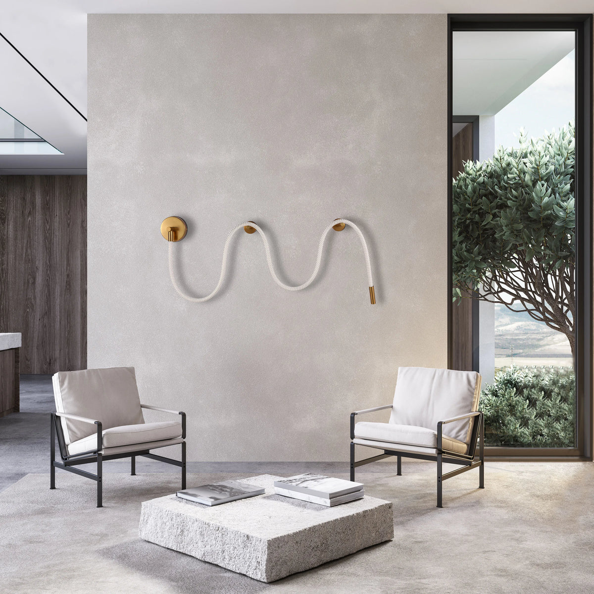 A statement rope wall light with gold details illuminates the scene. Natural light streams in from a window showcasing lush greenery.