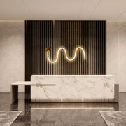 Stylish reception area with a wavy, warm light feature and marble countertop, creating a modern, inviting ambience.