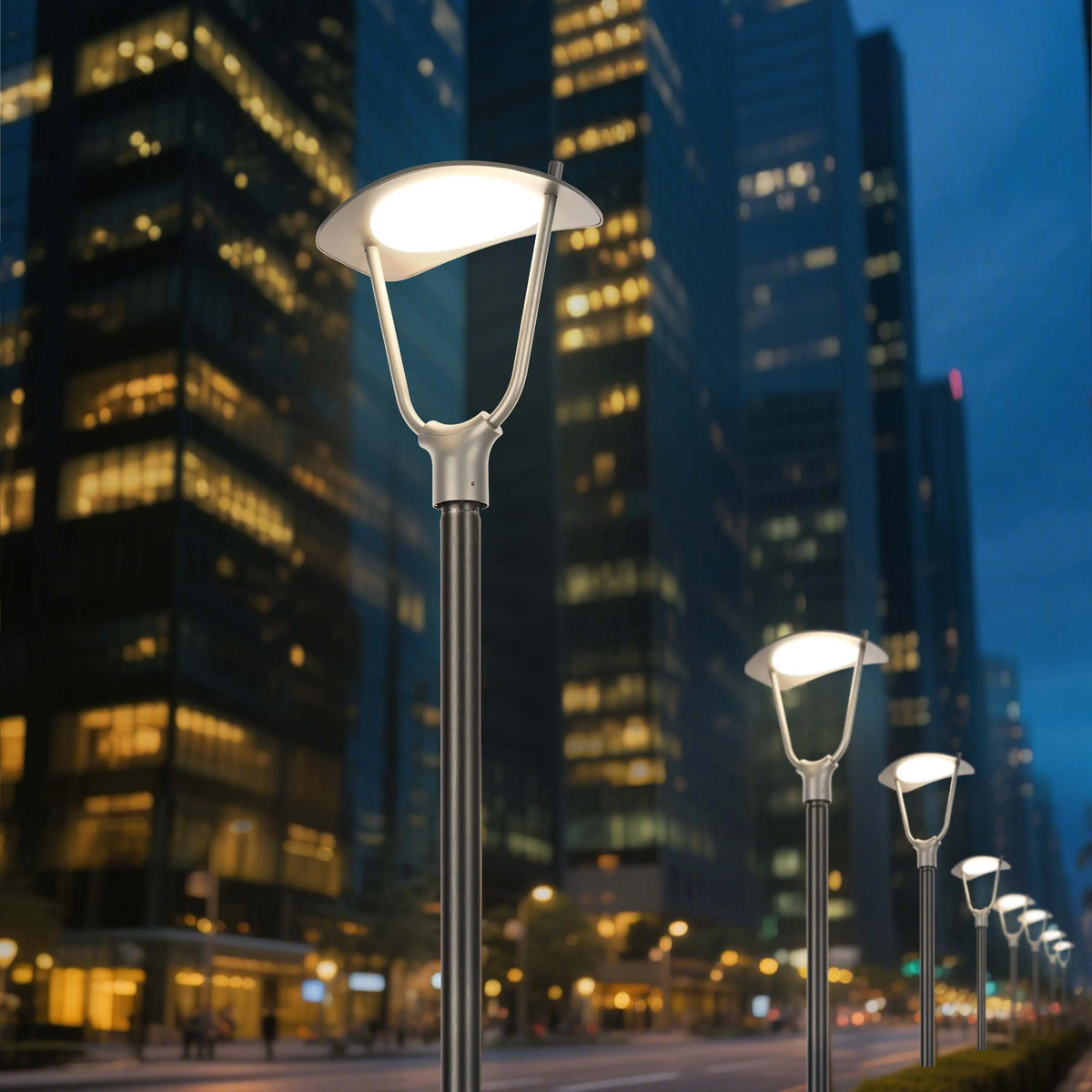 Modern street lights illuminate an urban landscape at dusk, with blurred high-rise buildings as a backdrop.