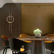A striking circular wall light with brass detailing gives a modern touch to this dining area. Its warm glow enhances the space.