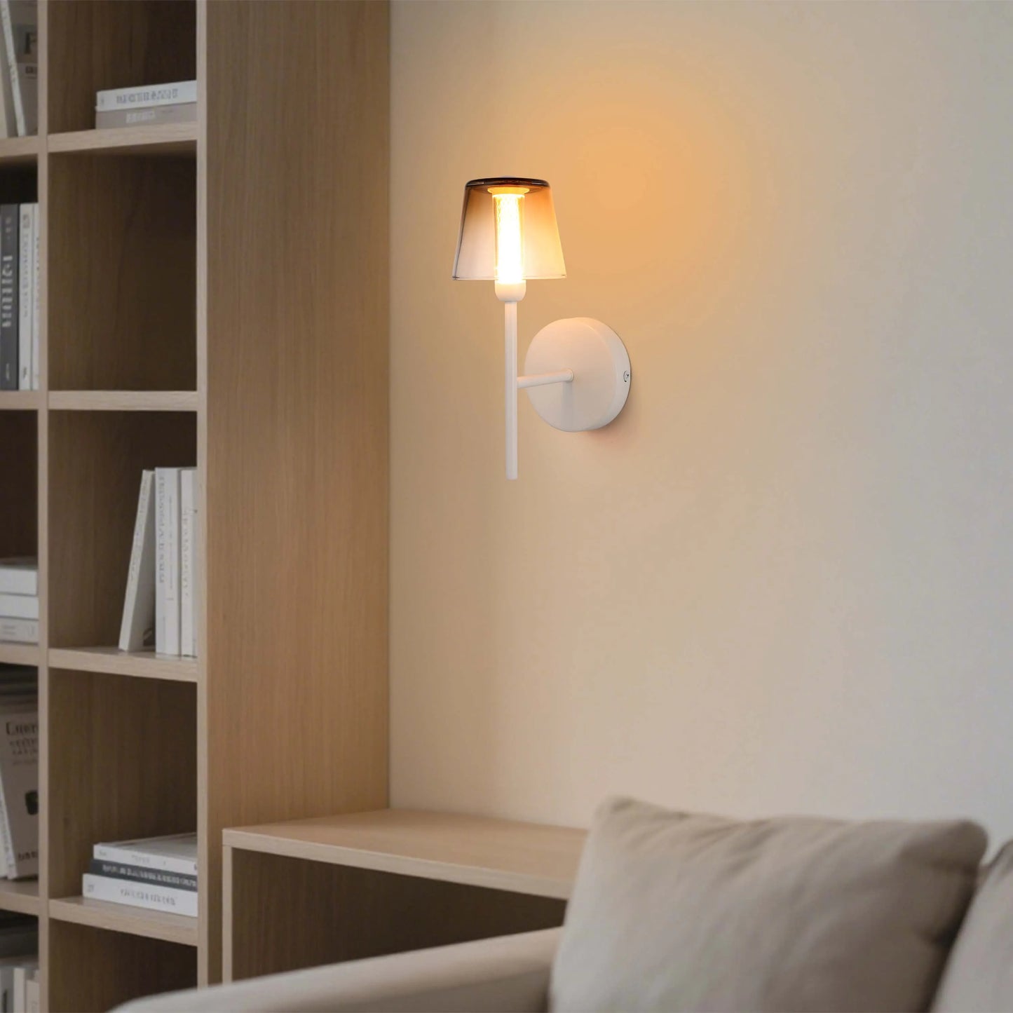 A wall-mounted light fixture with a shade emits a warm glow, creating a cosy and inviting atmosphere in the room.