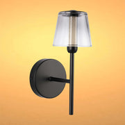 A stylish, matte black wall light with a clear shade, providing a warm and inviting glow. Modern elegance for any room.