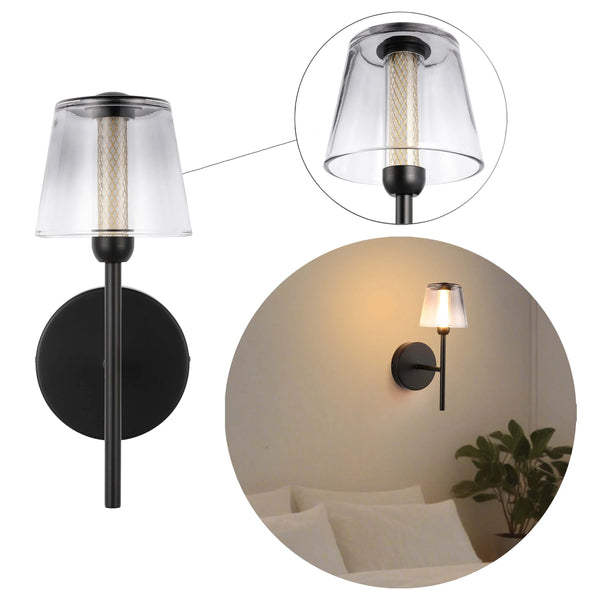 A black wall light with a transparent shade that lets the warm light from the bulb shine through.
