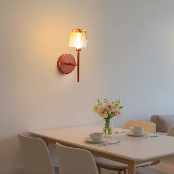 A modern wall light with a copper finish, casting a warm, inviting glow in a dining area.