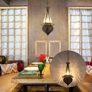 A Moroccan-style hanging light fixture adds a touch of exotic charm to this dining area, casting a warm, inviting glow.