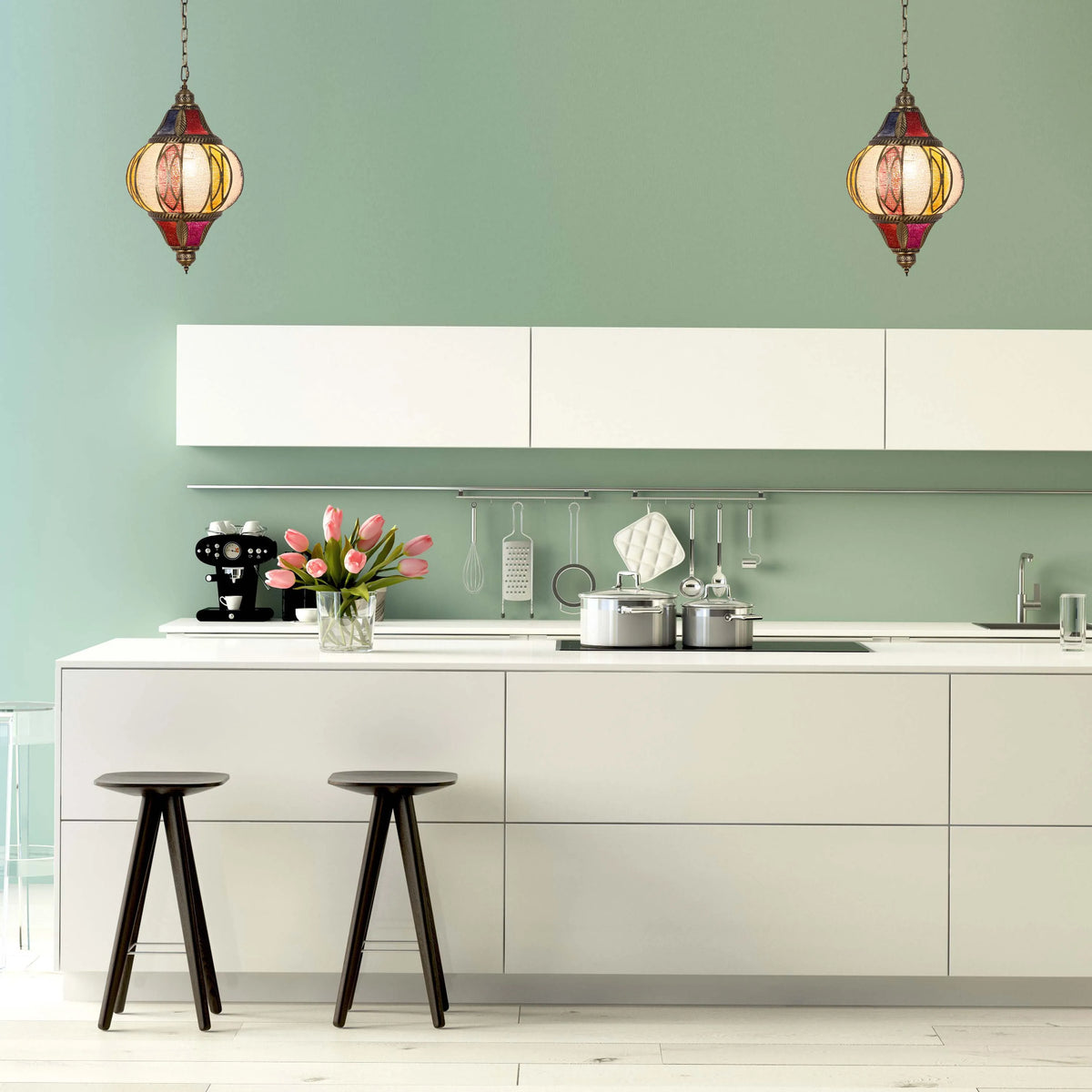 A pair of colourful pendant lights hang above a modern kitchen island, adding a touch of character to the contemporary space.