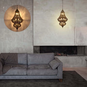 Ornate metal pendant lights cast patterned shadows. One is highlighted with a circular shape in this cozy living room setting.
