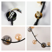 A modern sputnik light fixture with smoked glass and golden glass baubles on a black frame.