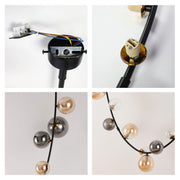 A modern chandelier featuring a black metal frame with glass globe shades in varying colours and textures.