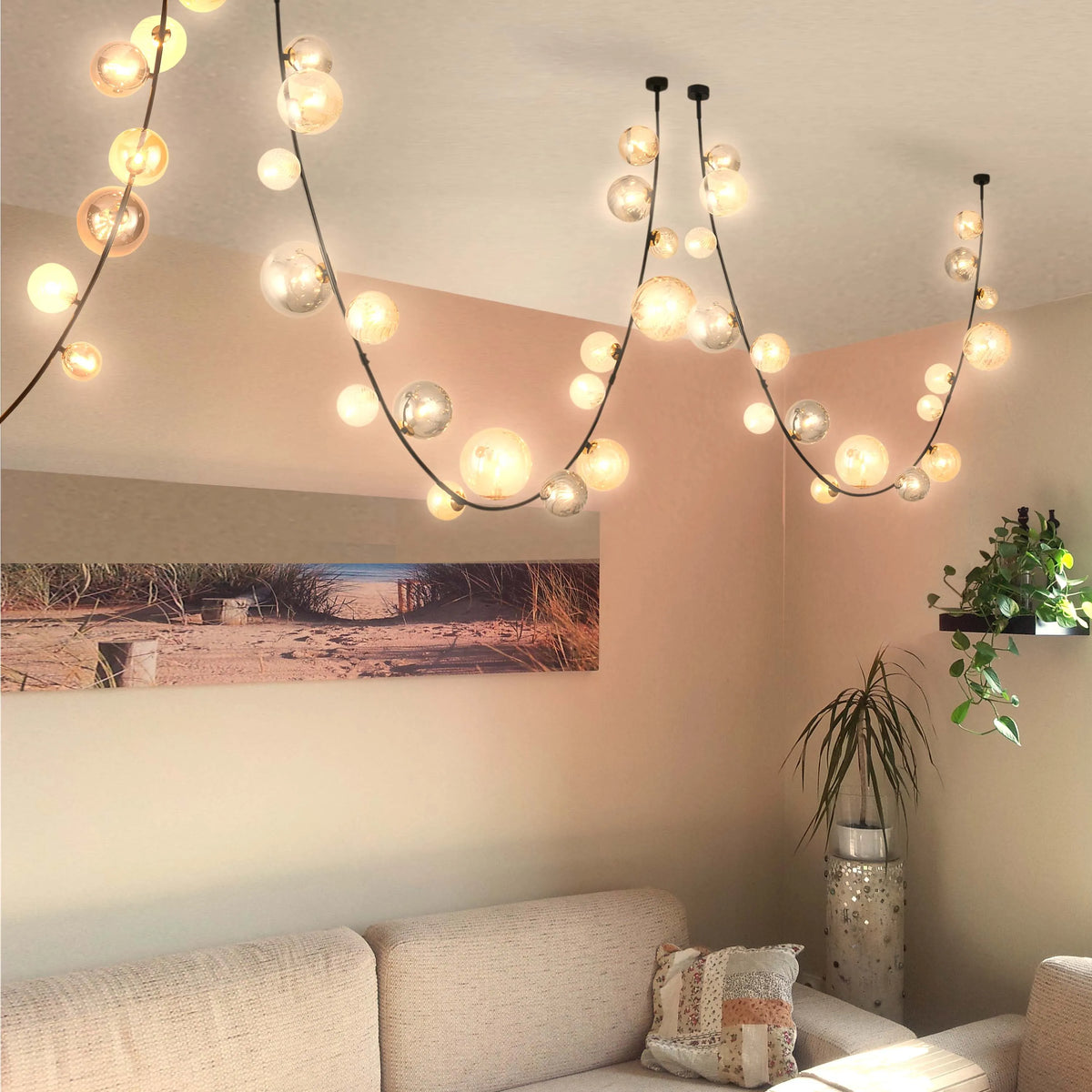 Contemporary bubble chandelier featuring globe lights strung along black wires, adding a warm and modern touch to the room.