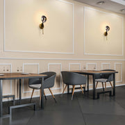 Elegant wall sconces cast a warm glow, adding a touch of sophistication to this modern dining space.