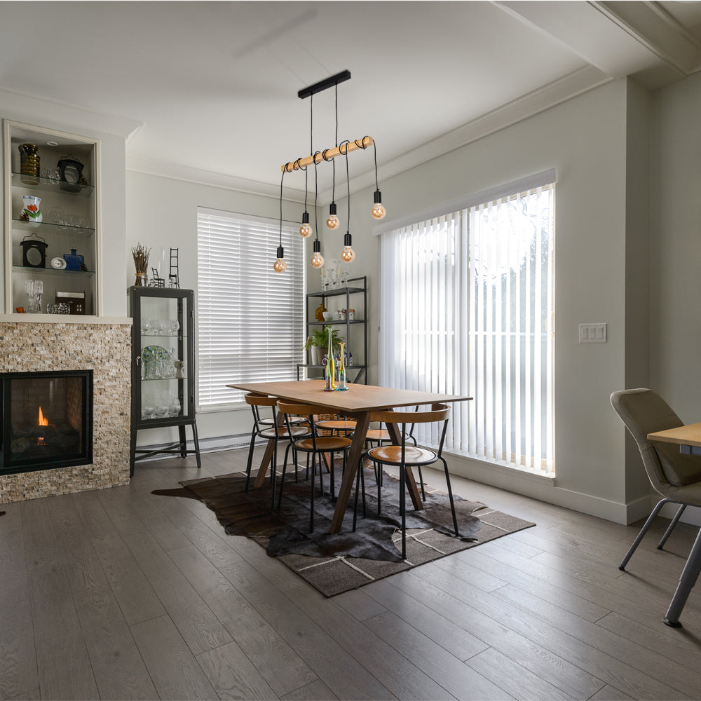Statement pendant light with six Edison-style bulbs, hanging over a rustic dining table.
