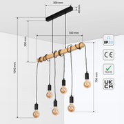 Industrial pendant light with five exposed bulbs hanging from a wooden beam, suspended by black cables.