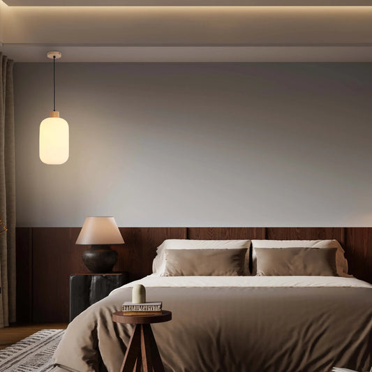 Ambient lighting with a hanging pendant lamp and a table lamp creates a warm and inviting atmosphere in this bedroom.