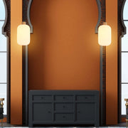 Two pendant lights hang either side of a recessed unit. The lanterns are cylindrical with a warm, ambient glow.