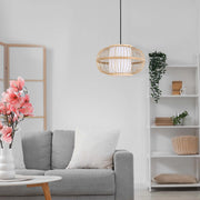 A bamboo pendant light hangs in a bright living room with white walls and neutral furnishings.
