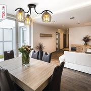 Amber glass black semi-flush ceiling light with 3xe27 fitting in indoor setting dining table top