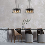 Black caged metal amber cylinder glass chandelier with 3xe27 fitting in indoor setting dining room